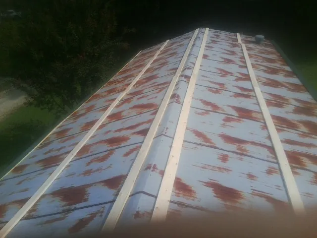 Rusted metal roof panels with new wood purlins before replacement — Storm Damage Roof Repair in Homewood by Roofing Brothers