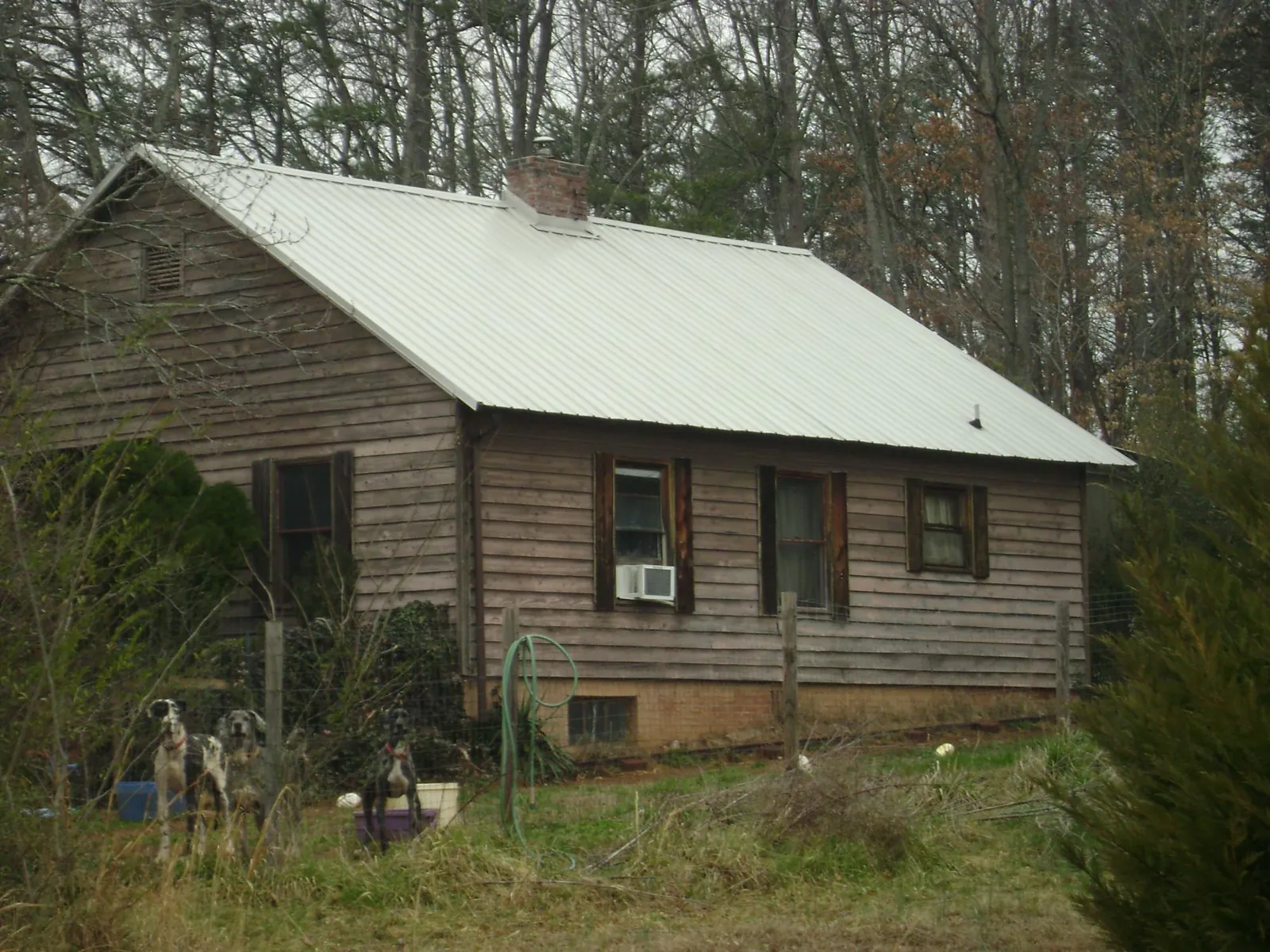 White metal roof on an old wood sided farmhouse, from a Metal Roof Installation job in Homewood